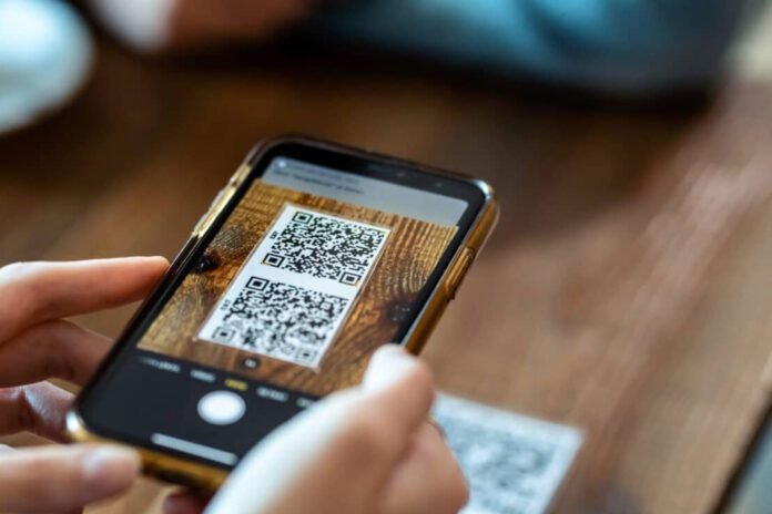 Young woman hands using the smart phone to scan the qr code to s